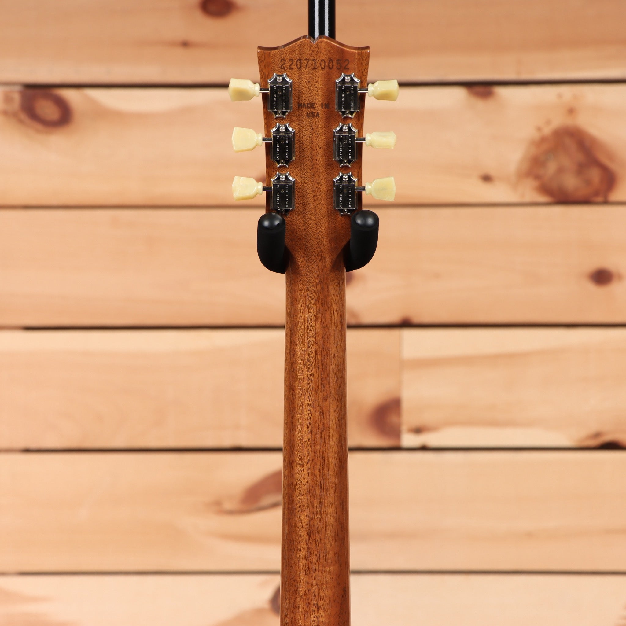 Gibson Les Paul 70s Deluxe Gold Top electric guitar with dual humbuckers and black rear view on wooden background