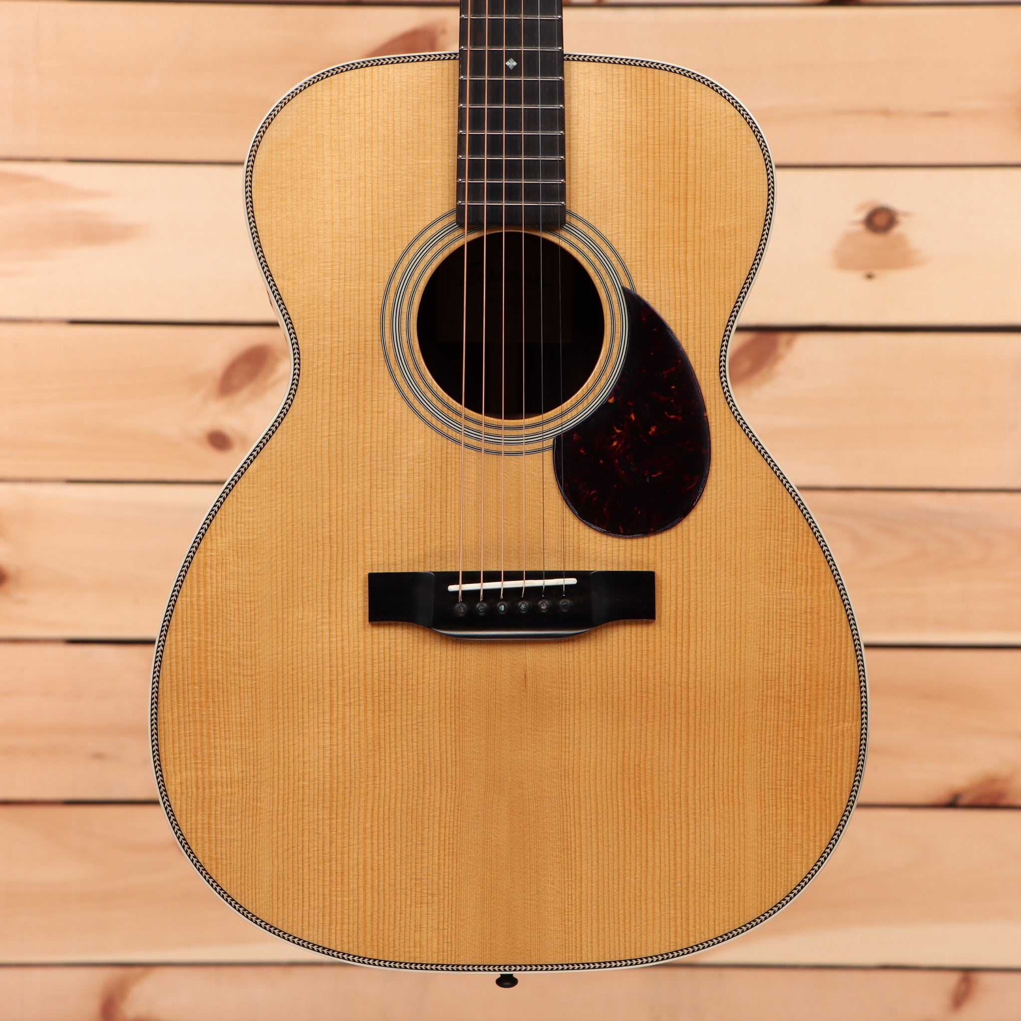 Eastman E20OM-TC natural acoustic guitar with tortoiseshell pickguard and rosewood fretboard