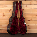 Taylor 818e hardshell guitar case open showing red velvet interior with gold hardware and embossed exterior