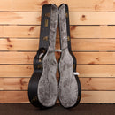 Eastman E20OMMRTC natural acoustic guitar case open showing gray velvet interior with brass hardware