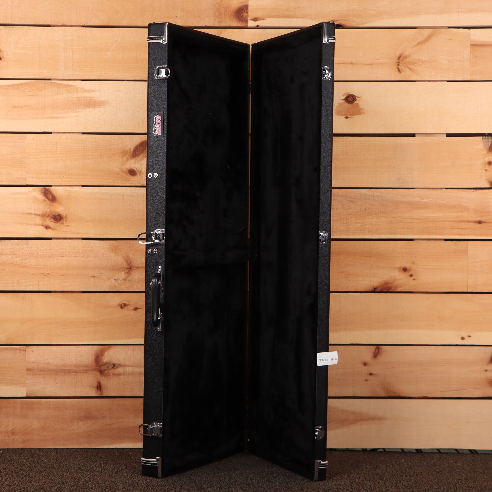 Gator Cases black hardshell guitar case open showing black velvet interior with chrome latches and handle