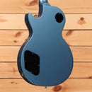 Blue electric guitar single-cutaway body with black pickup covers and control cavity back view