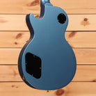 Blue electric guitar single-cutaway body with black pickup covers and control cavity back view