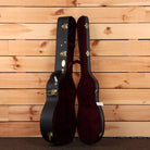 Martin Custom Shop NAMM 2026 Custom #5 hardshell guitar case open showing black exterior gold hardware and burgundy velvet in