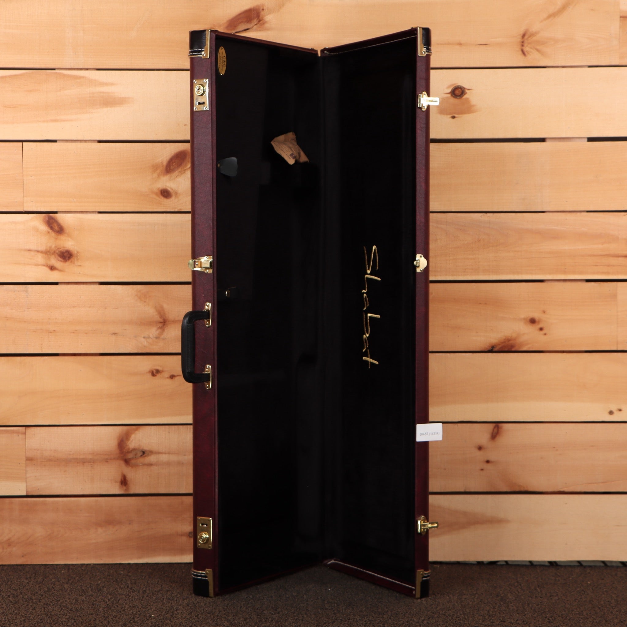 Shabat guitar hardshell case burgundy exterior with black interior gold hardware and Shabat signature logo