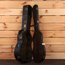 Martin 000-18 Golden Era acoustic guitar hardshell case open showing dark plush interior with gold latches