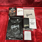 Gibson 70s Explorer Classic White guitar accessory package with warranty card, safety manual, polishing cloth, and strap butt