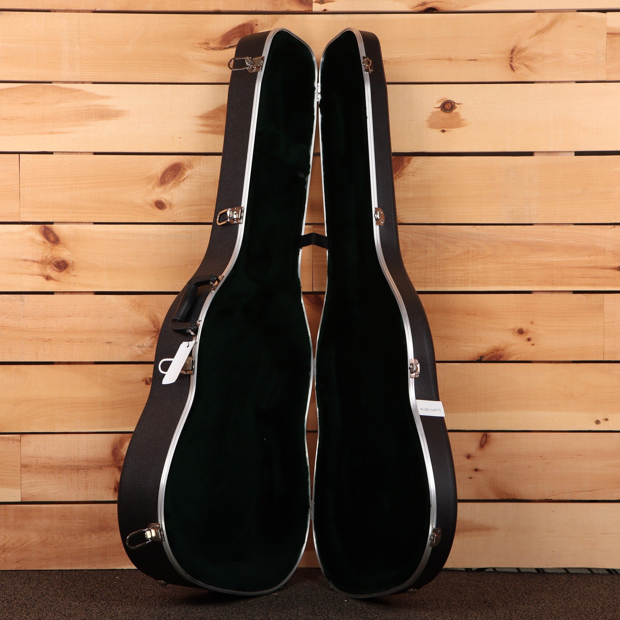 Martin 00-28 acoustic guitar hardshell case open showing black interior with silver latches and chrome hardware