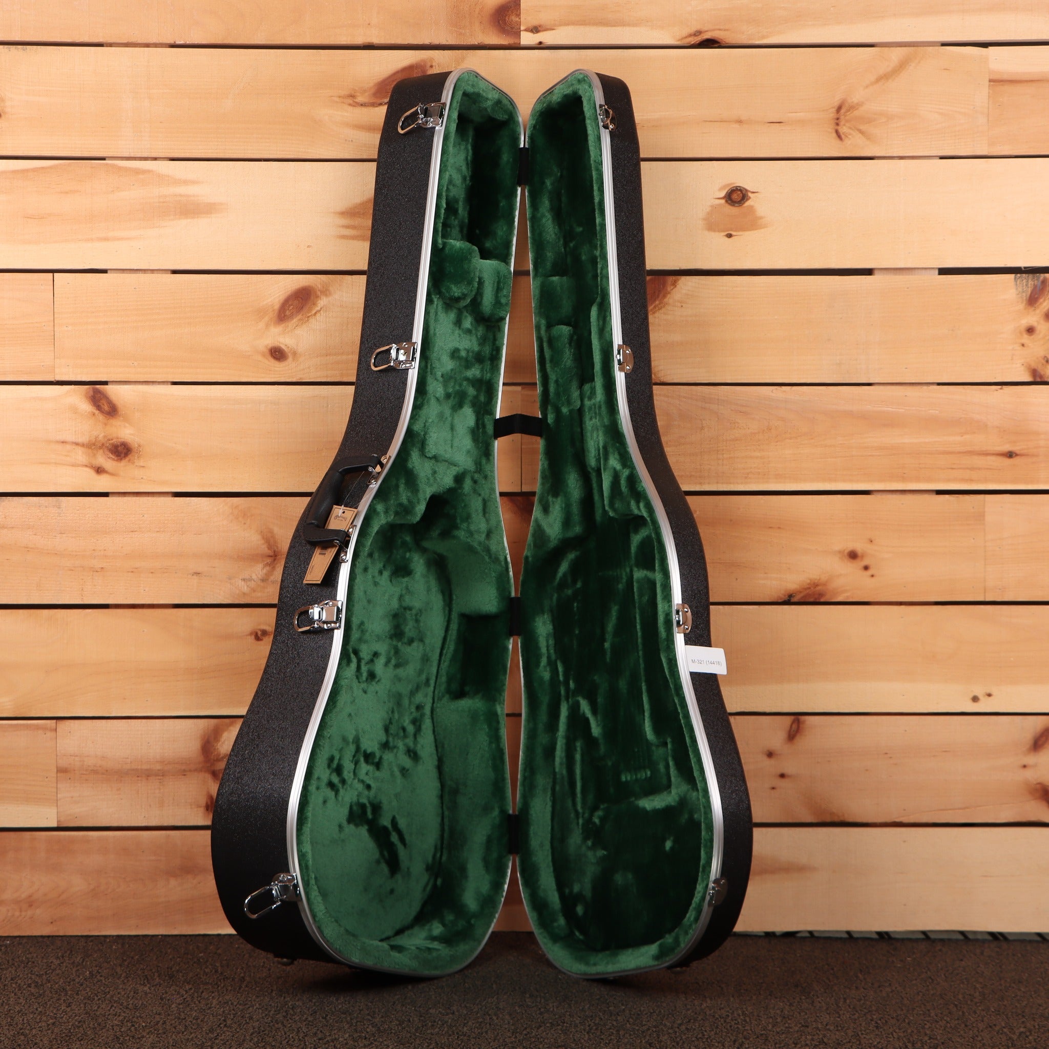 Martin HD-28 dreadnought acoustic guitar hardshell case open showing green plush interior with chrome latches
