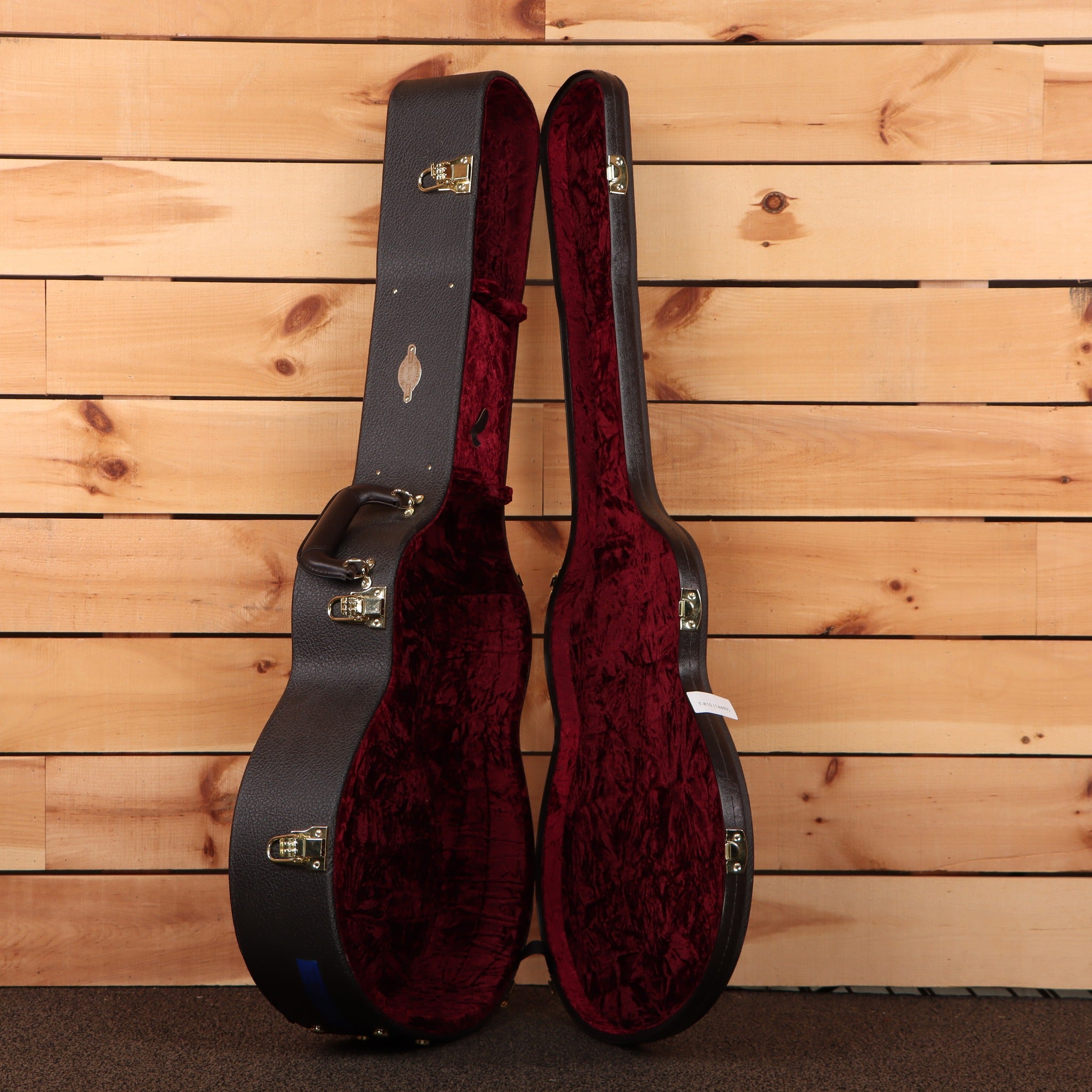 Taylor K28e Shaded Edgeburst acoustic guitar hardshell case open showing black exterior with red velvet interior and gold lat