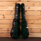 Bourgeois Touchstone Soloist OMC guitar hardshell case open showing black exterior and green velvet interior lining
