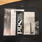 PRS CE-24 McCarty Burst guitar gig bag with warranty card, operating instructions booklet, and accessories pack