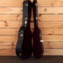 Martin D-41 acoustic guitar hardshell case open showing black exterior gold latches and burgundy plush interior lining