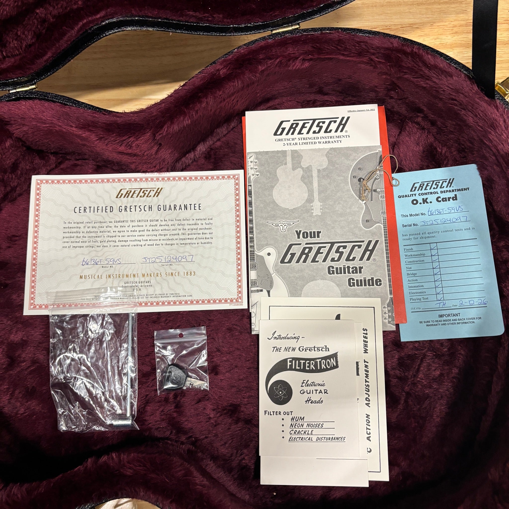 Gretsch G6136T-59 Vintage Select Falcon case interior with warranty card, guitar guide, and FilterTron pickup pamphlet