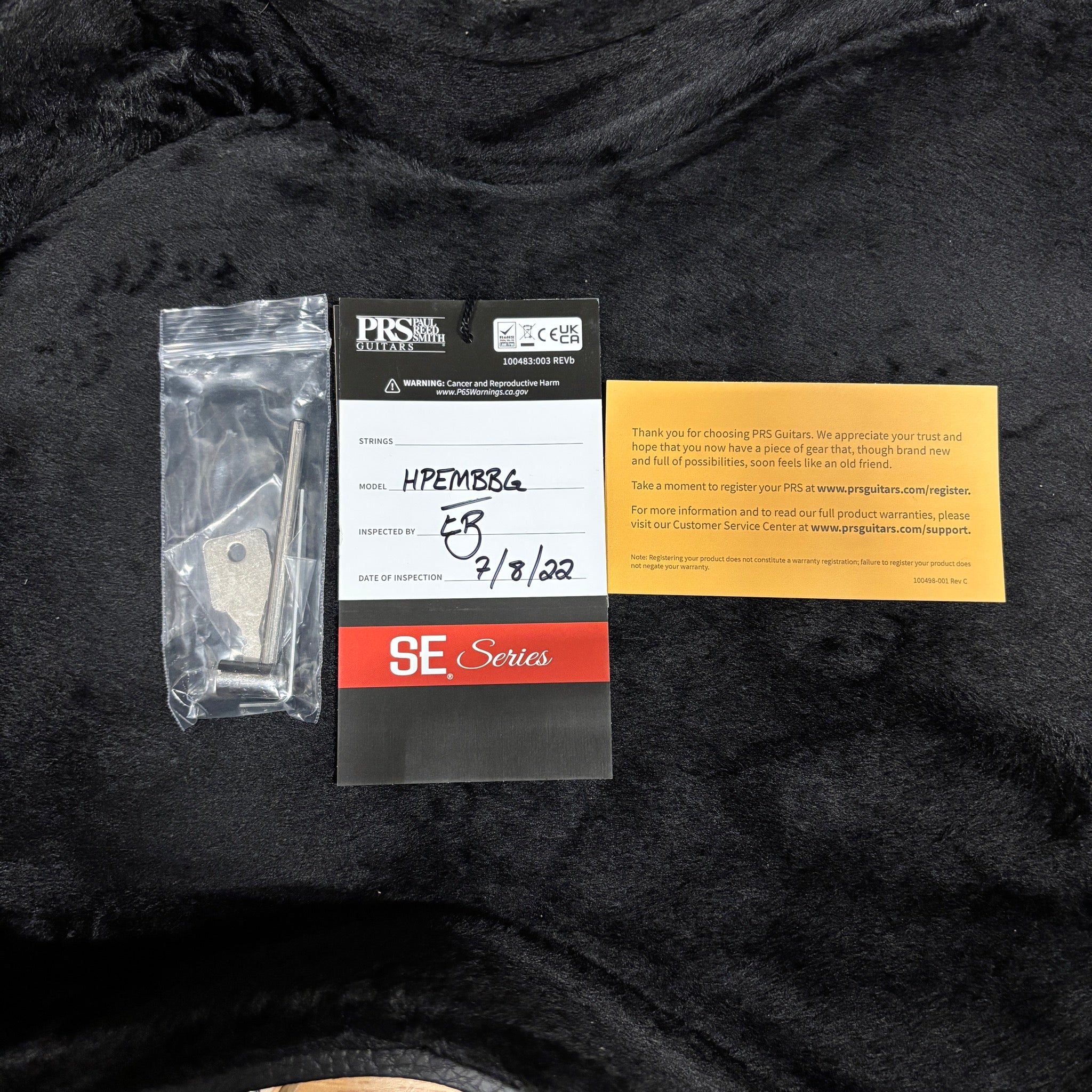 PRS SE Hollowbody Piezo Black Gold Burst guitar hang tag, warranty card, and tremolo arm accessory pack