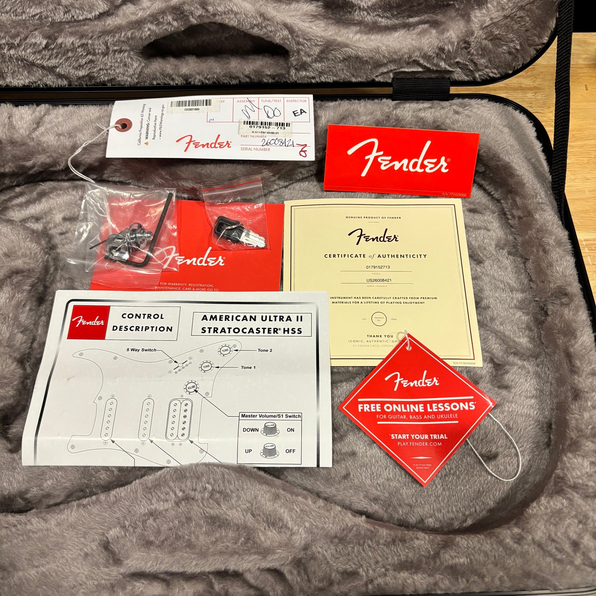 Fender American Ultra II Stratocaster HSS accessories bundle with certificate of authenticity, control diagram, and hardware
