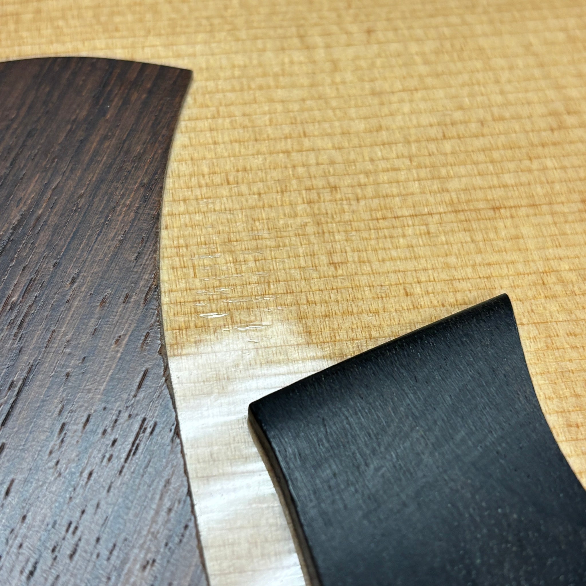 Taylor 818e Natural acoustic-electric guitar close-up showing flamed maple top with ebony fretboard detail