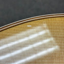 Taylor 818e Natural acoustic-electric guitar close-up showing flamed maple back with tortoise binding detail