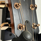 Taylor 724ce acoustic-electric guitar Natural finish close-up of headstock with gold tuning machines and walnut binding