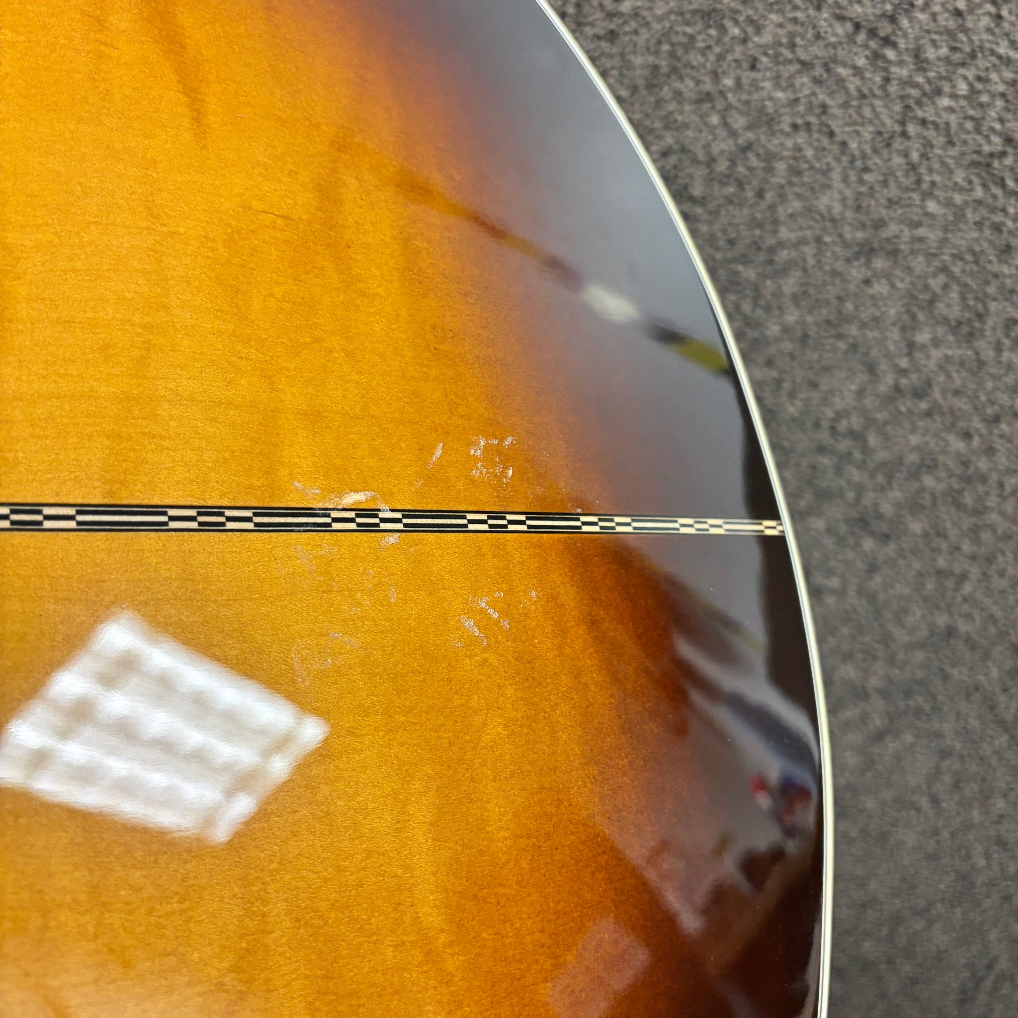Gibson SJ-200 Standard acoustic jumbo guitar Sunburst finish close-up showing checkered binding and body damage