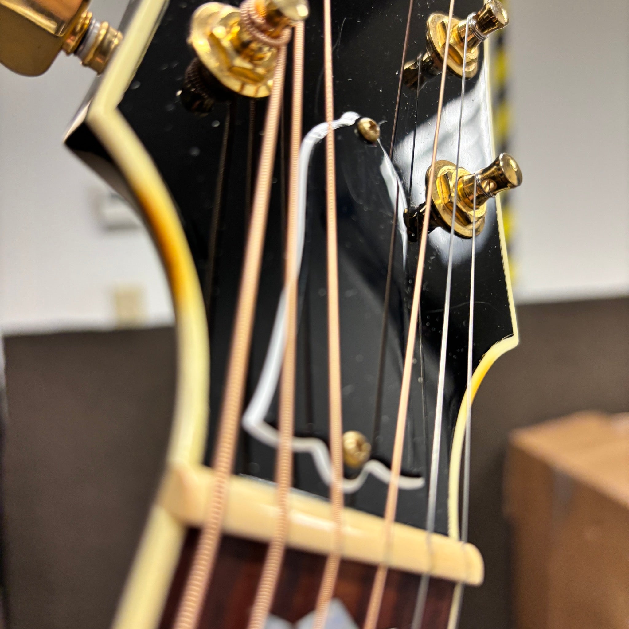 Gibson SJ-200 Standard acoustic guitar Sunburst closeup headstock with gold tuners and cream binding
