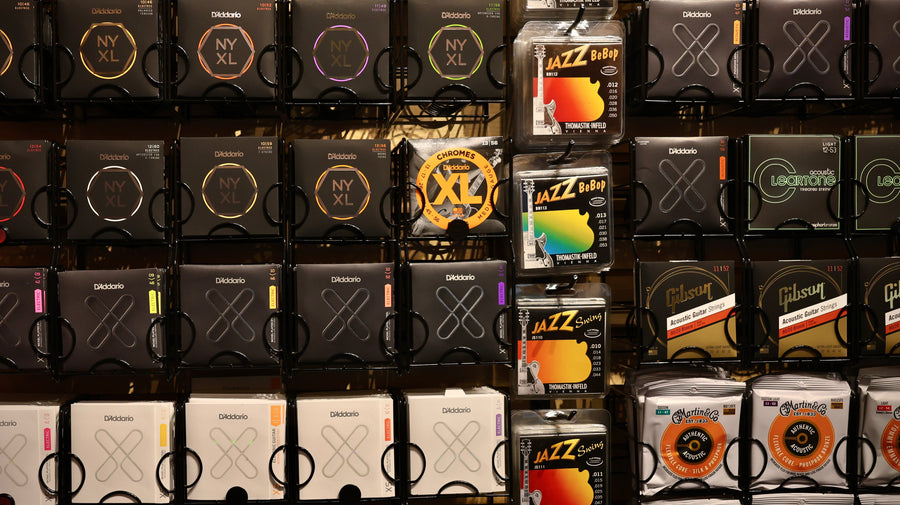 Display of guitar strings in various packaging on a shelf