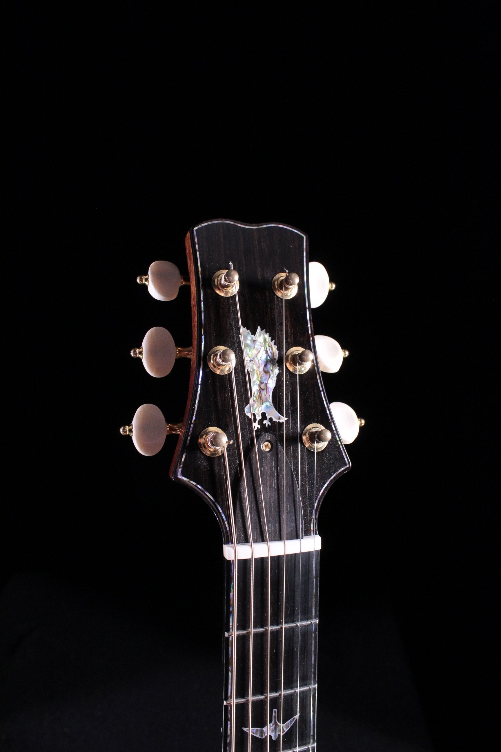PRS Angelus acoustic guitar headstock with abalone eagle inlay gold tuners and ebony faceplate