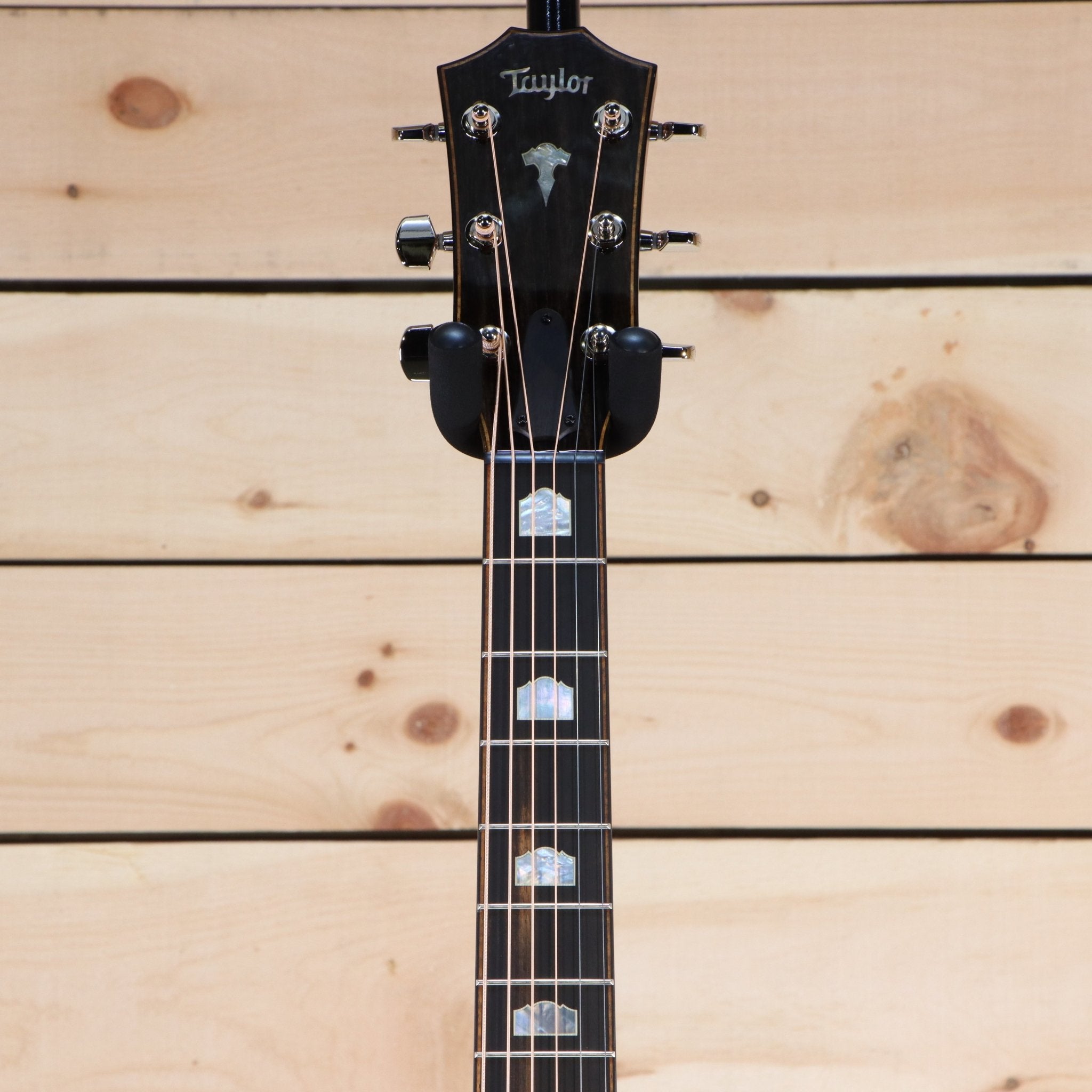 Taylor 818e Grand Orchestra acoustic-electric guitar headstock with ebony fretboard and mother-of-pearl inlays