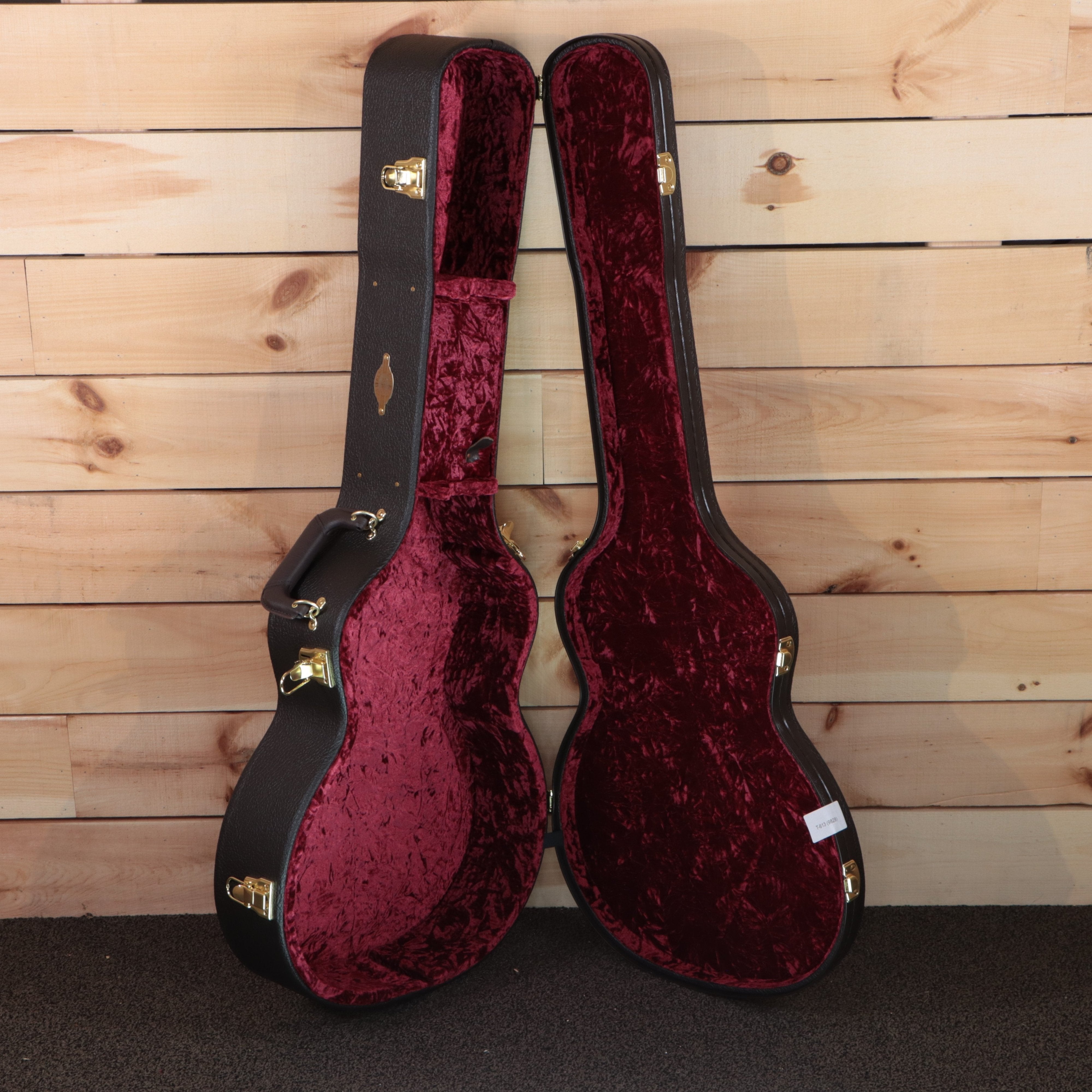 Taylor Custom GA acoustic guitar hardshell case open showing burgundy velvet interior with gold hardware